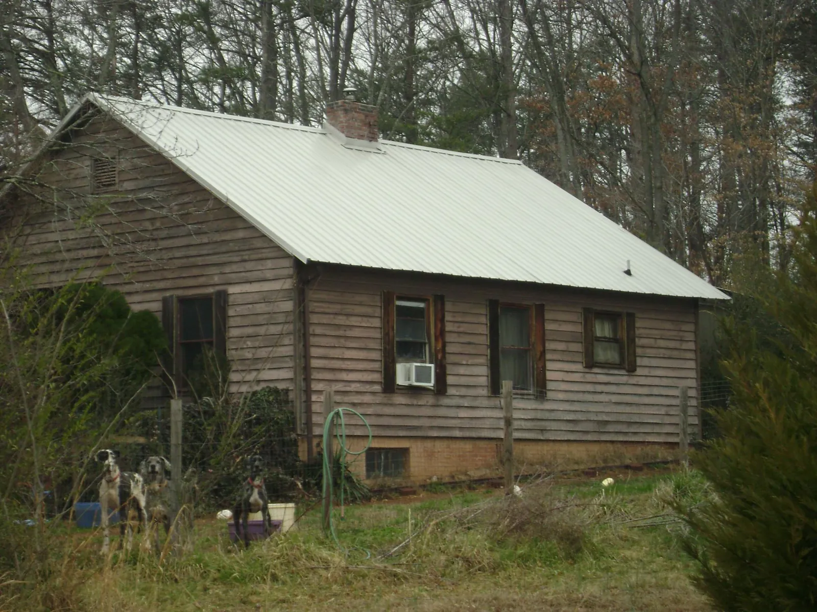 White metal roof on an old wood sided farmhouse, from a Metal Roof Installation job in Calhoun
